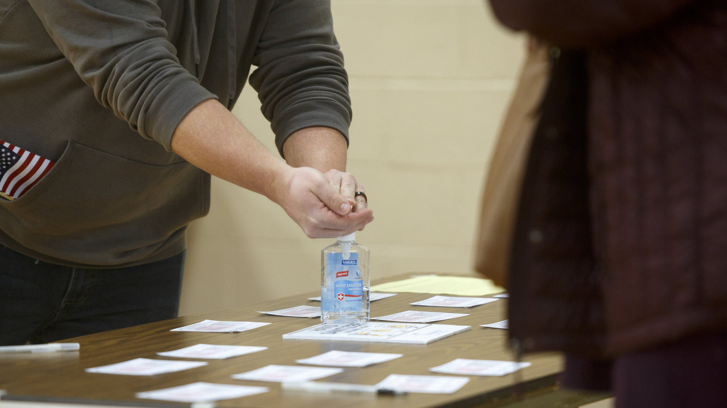 voter using hand sanitizer